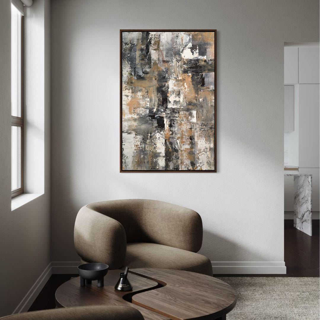 Abstract painting on a wall above a modern armchair in a living room.